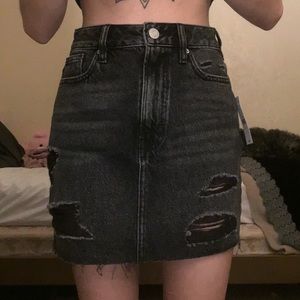 Black distressed jean skirt. Silver buttons.